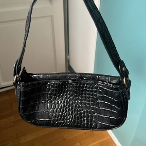 Svart baguette väska - Svart väska i ormskinn imitation