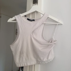 Asymmetrisk topp  - Asymmetrisk Croptop från Bikbok   Använd ett par gånger men fortfarande i bra skick   Snöret på höger sida ska stoppas i och används endast för hänga på galge 