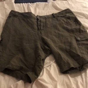 Shorts  -  Snygga gröna shorts Med en stjärna som en liten detalj på sida sex fickor två på sidan två där uppe och två där bak