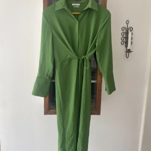 Ärtgrön klänning från Reserved - Omlott skjortklänning i ärtgrön. Sval och skön. Oanvänd. 