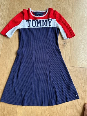 Tommy Hilfiger klänning (blå/vit/röd) - Tommy Hilfiger klänning storlek 7 - köpt till dottern när hon var 9 år. Motsvarande storlek 134-140. Bra kvalitet och i fint skick - använd max 5 gånger. (80% bomull, 17% nylon, 3% elastin)