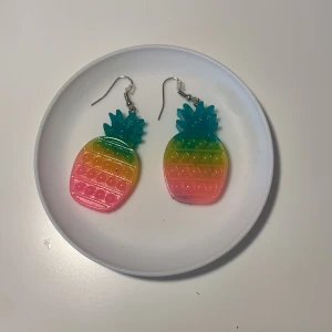 Pop it ananas örhängen  - De har regnbågens färger och är formade som en ananas 🍍 