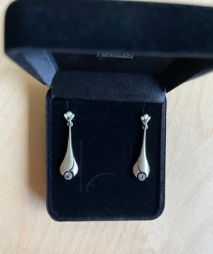 Finnfeelings Örhängen med bergskristall  - Finnfeelings Örhänge, hängande droppformad med bergskristall. Aldrig använda.   Detta klassiska tidlösa smycke i skandinavisk design passar till alla ändamål. Smycket är matterat och sedan lackat för att behålla sin speciella design. 925 sterling silver.