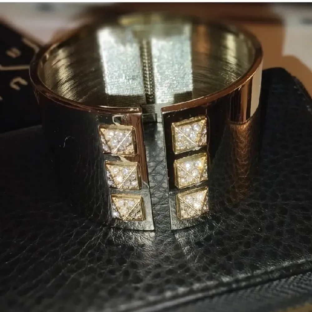 Victoria`s Secret armband i guld med nitar finns nån liten repa men annars i fint skick. Accessoarer.