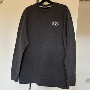 Blå/grå Vans tröja  - Blå/grå Vans tröja med vitt tryck i fram och i bak