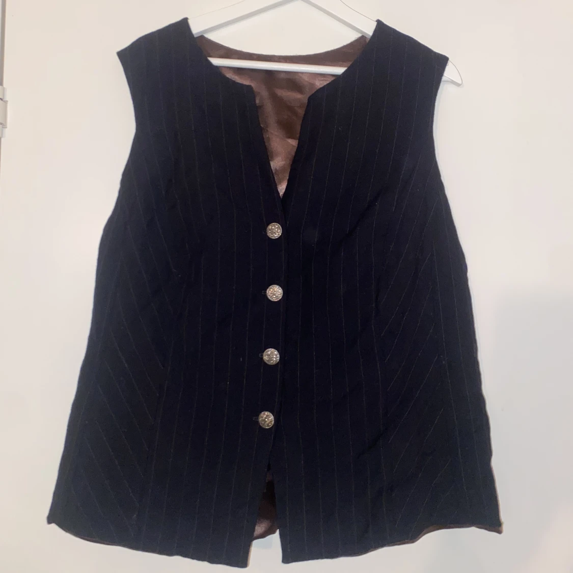 Randig svart väst med silvriga knappar