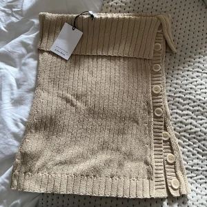 Tub topp - En beige stickad tub topp med knappar på sidan från & other stories! Aldrig använd så den är så gott som ny, där av är prislappen fortfarande på haha. Nypris 590kr 