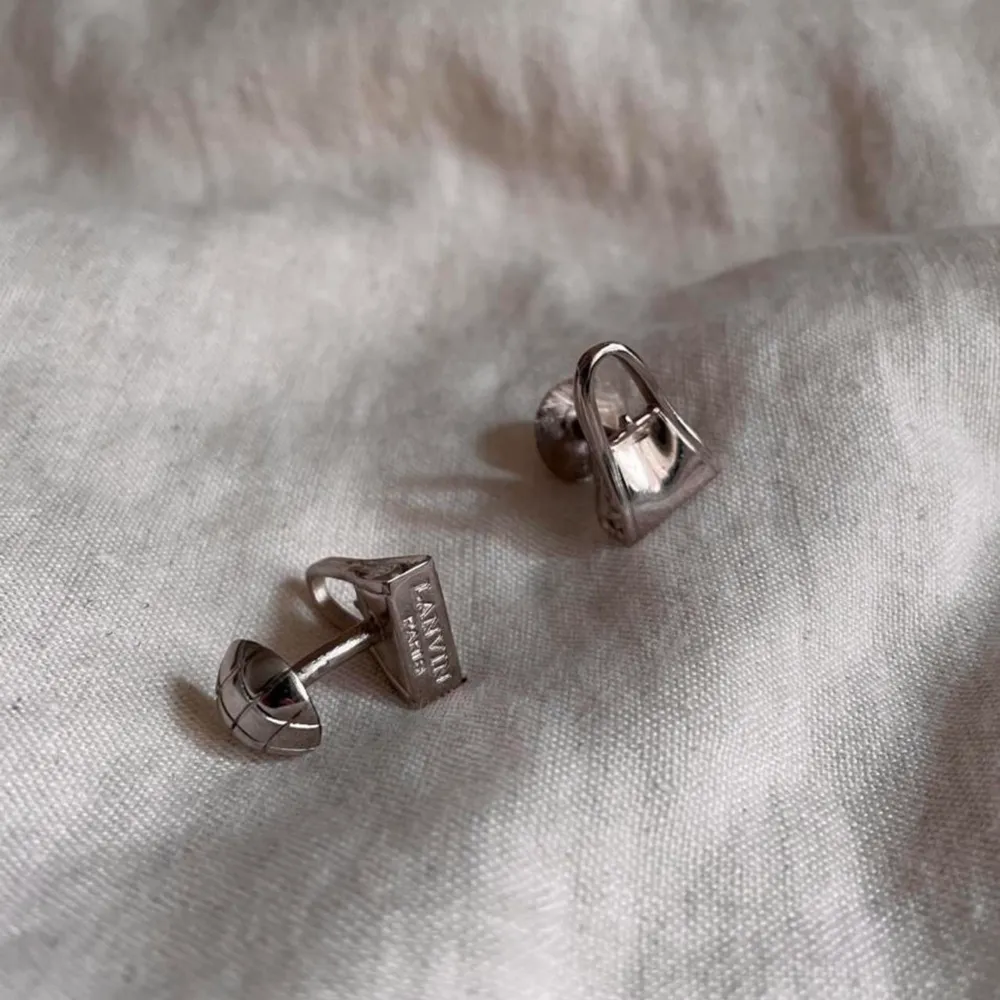 Gorgeous Designer Cufflinks from Lanvin. Unique Find! Solid Metal Purse Design with Embossed Branding at Base of Links Silver Color. Accessoarer.