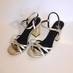 Klackar - Superfina guldiga och silvriga klackar från HM. Storlek 37 och sparsamt använda. Kanterna på klacken har blivit lite nötta men utöver det är skorna i fint skick 🌼