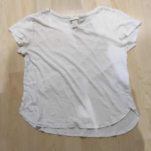 En enkel helt vit T-shirt. Rundad i neder kanten