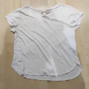 En enkel helt vit T-shirt. Rundad i neder kanten