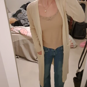 Lång kofta - En lång, gärddvit, öppen kofta. Storlek S.