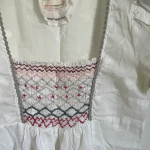 Odd Molly topp - Söt vit topp från Odd Molly med brodering i friskt tunt material, lite smått genomskinligt. Passform: åtsittande över bröst sen utsvängande neråt. Skick: fint skick, lite smått gul i armhålan men syns knappt.