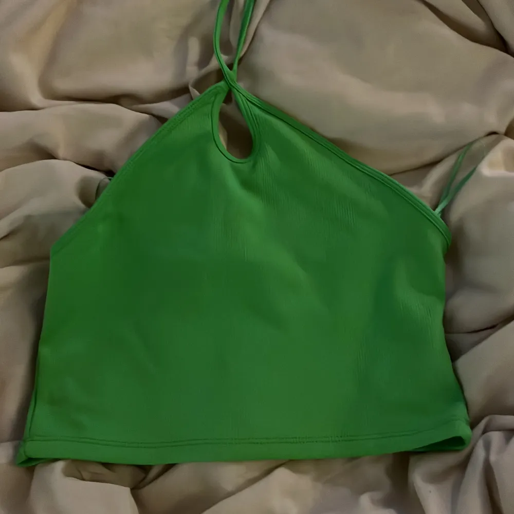 Säljer denna gröna top med knute runt halsen. Använd någon gång. . T-shirts.