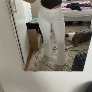Vita kostymbyxor nelly - Vita kostymbyxor med resår bak, bootcut och helt oanvända då jag råkade beställa 2 lika dana från nelly! 💞