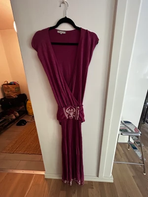 Stickad klänning  - Underbar stickad långklänning med band/skärp i midjan säljer jag billigt. Tyvärr är det en litet hål i midjan men är du händig med nål och tråd fixar du bort det. För bild kontakta mig så visar jag. Detta är ett fynd från House of Dagmar.