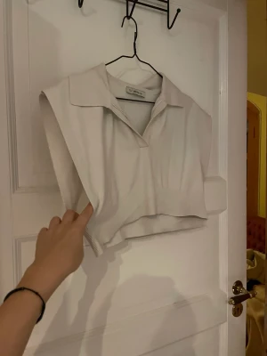 Vit stickad väst - Croppad väst, något grå/vit. Använt skick