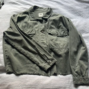 Grön jeansjacka oversize - Oversized och något croppad jeansjacka från zara. Relativt tunt jeans-material så funkar även som skjorta. Slitningar nertill. Knappt använd. 