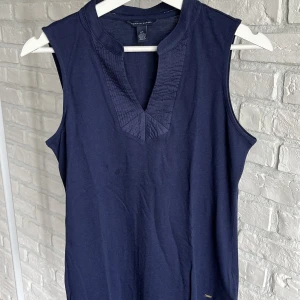 Tommy Hilfiger top - Marinblå Tommy Hilfiger top utan ärmar med delaj runt v ringningen. 
