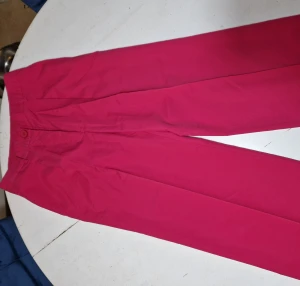 Kostymbyxor  - Knallrosa byxor, aldrig använda. 