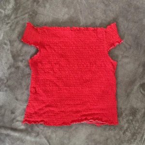 Röd topp - En liten enkel röd topp som är väldigt stretchig, går att styla på många olika sätt och den är knappt använd. 