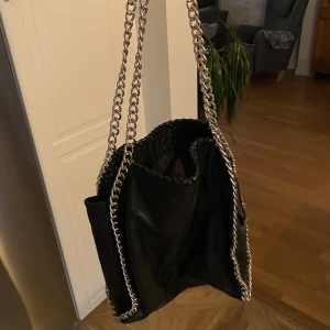 Tiamo Pricilla väska L - Säljer nu min fina Pricilla väska med kedjor från Tiamo. Fint skick bortsett från att jag fått sy pyttelite på insidan av väskan, inget som syns överhuvudtaget (se bild 3). Nypris: 599kr.