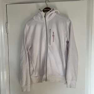 Sail Racing hoodie - Vit sail racing hoodie i storlek M.  Inga skador, men små fläckar som troligen går att trötta bort. Har ej testat själv eftersom hoodien blivit för liten. Tveka inte på att skicka DM vid frågor.