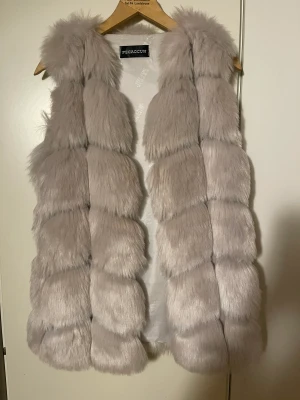 Pälsväst fur vit/grå - Fin Pälsväst fejk päls pecaocun Har två fickor  Står ingen storlek men passar xs-m 