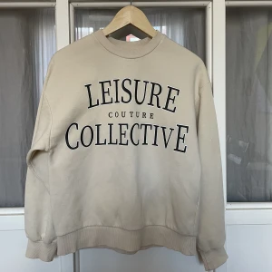 Gina college tröja, beige - Jättefin tröja från Gina Tricot. Tröja med oversize fit. Tröjan är beige och har ett tryck framtill. Sparsamt använd, i fint skick.