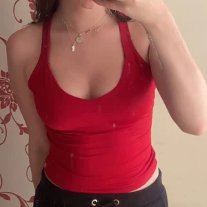 Rött linne - Ett rött linne med öppen rygg (typ?) se bilden. Den har mjukt och luftigt material och är stretchig!