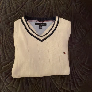 Stickad tröja - Säljer en V-ringad stickad Tommy Hilfiger tröja. Mycket fin tröja, endast en liten fläck på magen. Tröjan är storlek L.