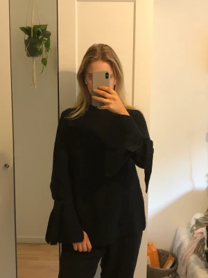 Stickad tröja  - Stickad tröja med knytning i armarna 