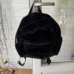 Svart väska  - Svart fluffig väska, den lilla fickans dragkedja har gått sönder och defekt förekommer på sista bilden💗