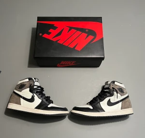 Jordan 1 Mocha - Jag säljer ett par Jordan 1 Mocha i Strl 41 då de har blivit för små. Skick: 9/10 bara använt ett fåtal gånger och man kan knappt se något. Autentisering och skydd mot fukt pulver ingår, samt box. Resell pris: 5000