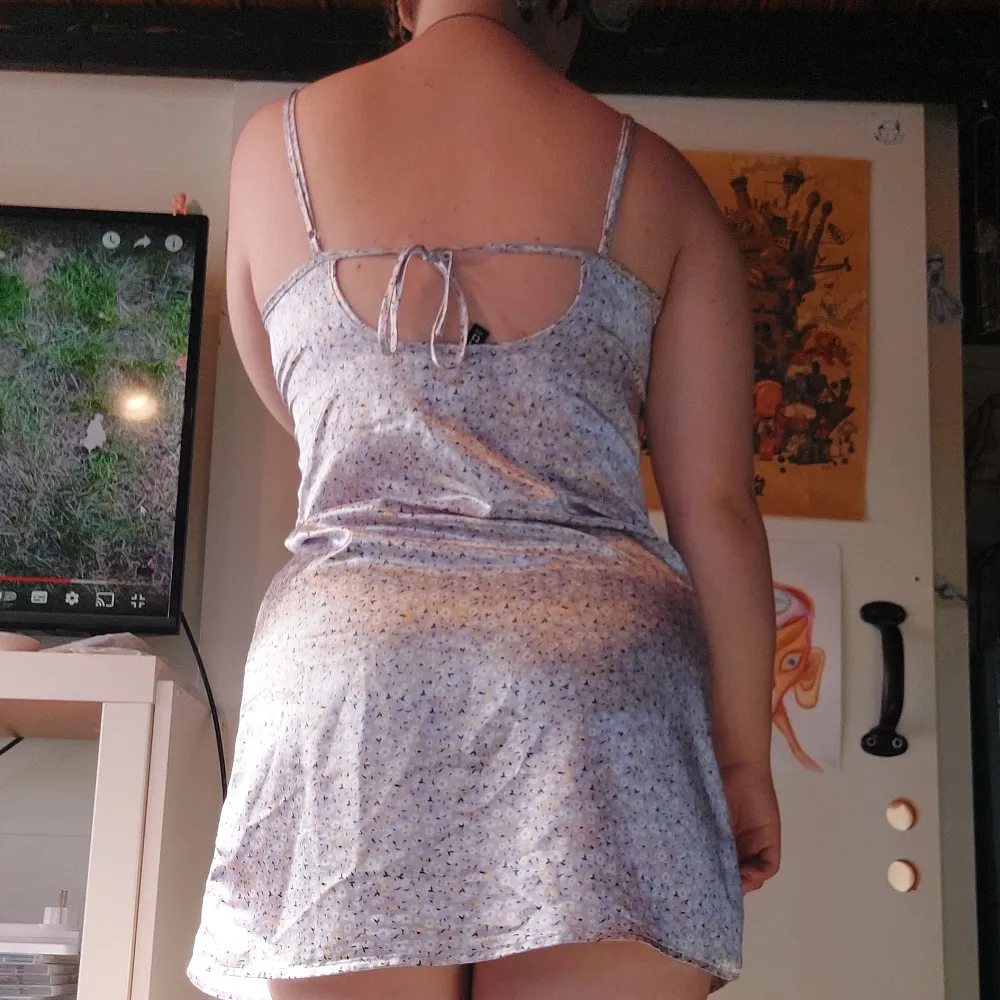 Kort klänning med öppen och knytbar rygg. Gjord i siden liknande material. Från hm. Klänningar.
