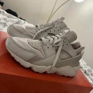 Nike Air Huarache  - Ett par huarache i färgen light bone/rattan/reflect silver/sail. I storlek 40,5, dock väldigt små i storleken så det motsvarar en 39. Använd endast vid 1 tillfälle, fortfarande i väldigt gott skick.