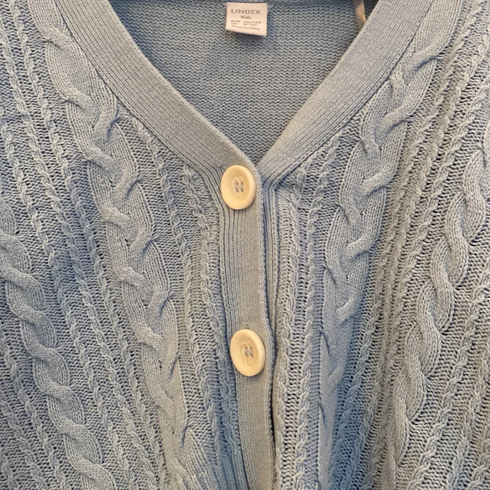 En blåa tröja/kofta med vita knappar, säljs för att den inte används (hon som bär tröjan är 163-164 cm)👌🏼❤️. Tröjor & Koftor.