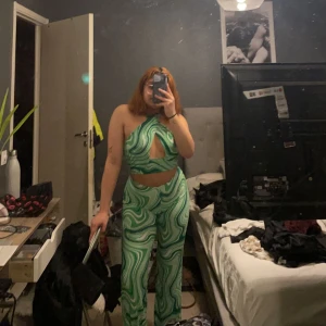 Grön topp - Grön swirl topp som är korsad över bysten. Kan även användas som en tub topp. Använd 2 gånger. Storlek S/M. Går att köpa tillsammans med byxorna som ett set, se anonsen om byxorna.