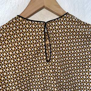 Wonderful material, pattern and small details. Long sleeves mustard yellow and brown pattern. 