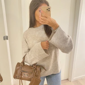 Beige stickad tröja  - Mysig stickad tröja i perfekt passform med utsvängda armar 