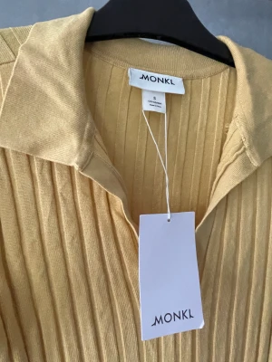 Solrosgul stickad klänning  - Inte genomskinlig, mjuk och stretchig. Aldrig använd. Passar M lika bra. 