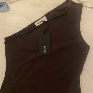 Oneshuldertopp - Oanvänd oneshouldertopp från weekday i mörkbrun färg