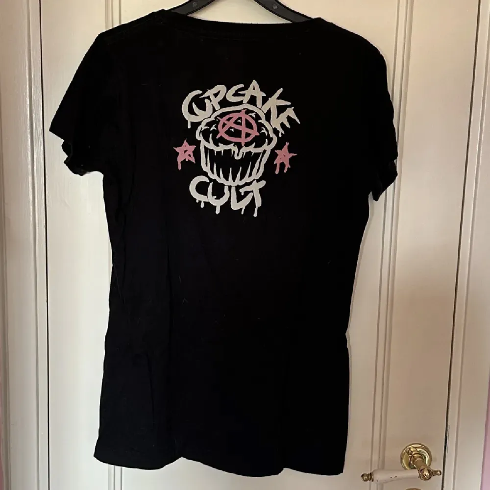 Svart T shirt från märket Cupcake cult. Storlek L men liten i storlek passar mer S-M.   Katter finns i hemmet.. T-shirts.