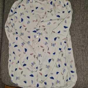 Blå mönstrad blus - Denna v-ringade blus är tunn och har blå mönster på den. Den är i bra skick och har inte kommit till användning och därför säljer jag den. Hör av dig vid frågor :)