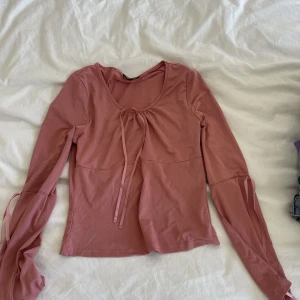 Rosa tröja - Inte kommit till användning och man ska knyta snörerna