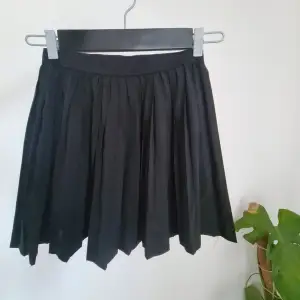 Plisserad kort kjol från H&M Divided. Storlek 34, 37 cm lång.