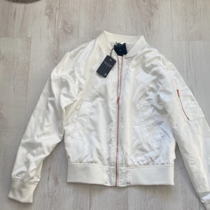 Sommarens Bomberjacka i siden HELT NY! - Vit helt ny bomber jacka i siden med prislapparna på med rosé dragkedja!  Stl XS