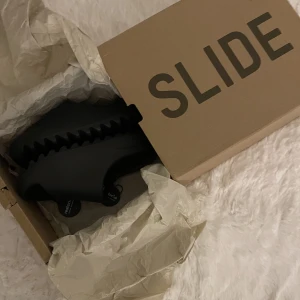 Yeezy Slides Onyx - Jag fick nyss hem dessa svarta Yeezy slidsen från restocks men de var tyvärr för små för mig därför säljer jag. De är i strl 38 men skulle säga att de skulle passa någon med strl 37. 
