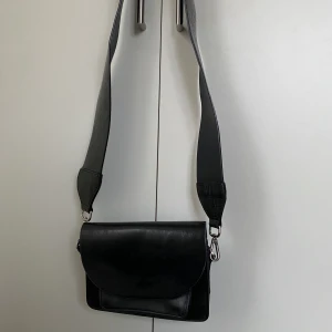 Väska från Carin Wester - Crossbody väska från Carin Wester i fint skick. Två axelband ingår, ett svart glansigt och ett grönt från Don Donna. Pris 300kr Finns i Kalmar, kan fraktas mot avgift💚