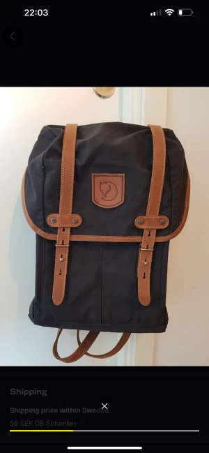 Fjällräven Retroryggsäck, nr 21 Medium - Svart Fjällräven ryggsäck i retromodell, med läderdetaljer. Många fack på både ut-samt insidan. Ett sittunderlag, som ingår, har ett eget fack som dubblar som skydd för din laptop. H42, B25, D12.  Bought as a gift for someone but unused